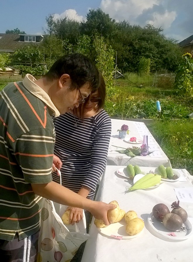 Arranging produce on the tables. Choosing the most uniform and shapely potatoes whilst three shapely and uniform beetroot look on.