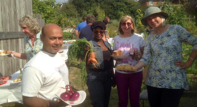 Happy plot holders showing off their winning entries. Onions: 1st prize, Carrot: Runner up in ugliest vegetable category, Coffee cake and Strawberry/Rhubarb jam: 1st prize in both categories, Potatoes: 1st prize