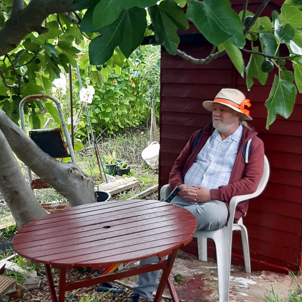 peter sitting at cafe table 2023