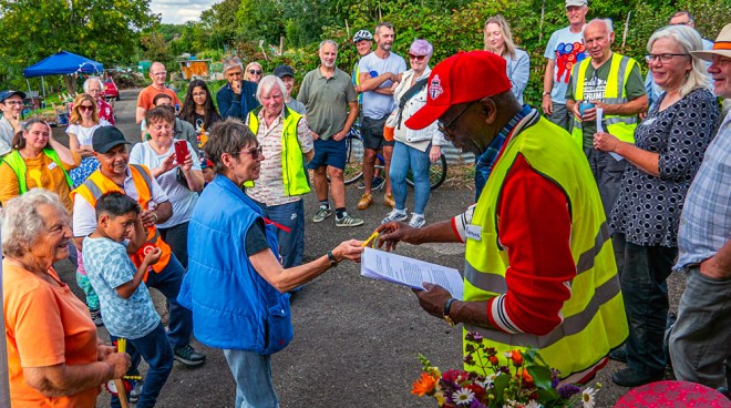 Chairman, Ray, is multitasking; delivering a speech and awarding rosettes in the produce show.